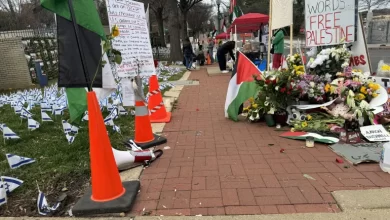 نشطاء يعلقون الأعلام الفلسطينية في محيط سفارة إسرائيل في واشنطن رفضا للحرب (الجزيرة)