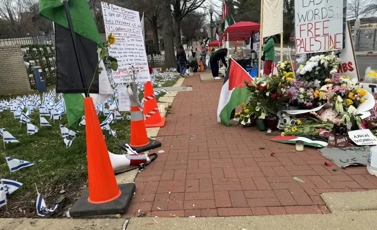 نشطاء يعلقون الأعلام الفلسطينية في محيط سفارة إسرائيل في واشنطن رفضا للحرب (الجزيرة)